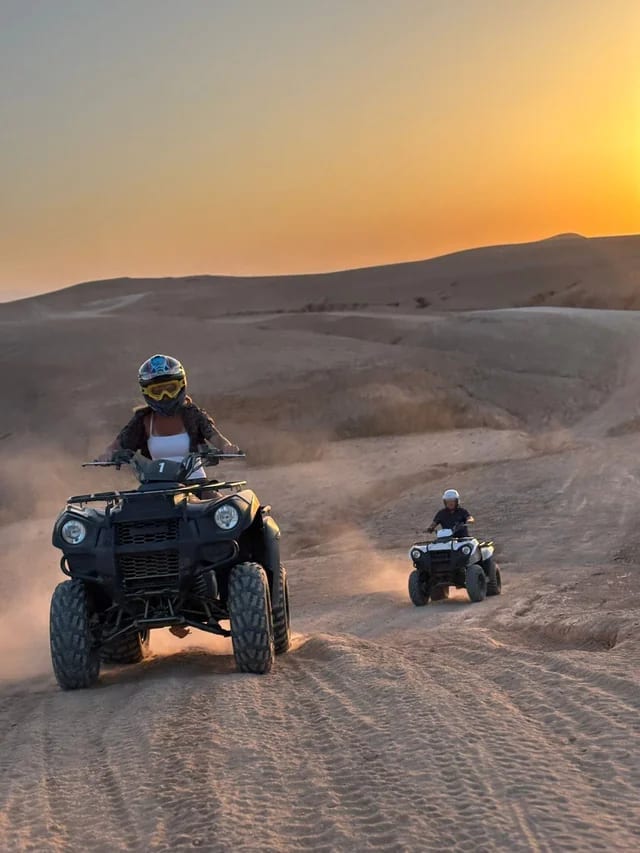 Deux quads sur une piste sableuse au coucher du soleil